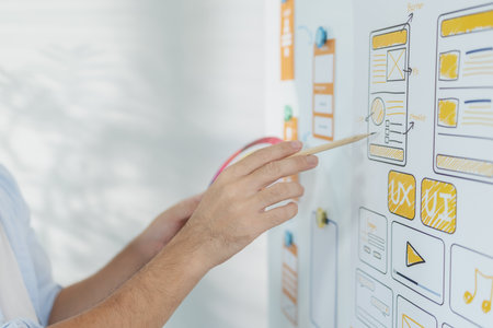 A creative designer is working on UX UI planning, reviewing wireframes, and adjusting color schemes...