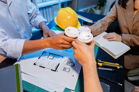 Engineers and architects analyze construction models and discuss project strategies, combining technical knowledge and creative ideas to achieve successful architectural design solutions.の写真素材