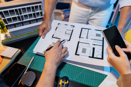 Engineers and architects analyze construction models and discuss project strategies, combining...