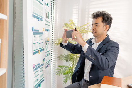 A business analyst examining charts and statistics on a whiteboard, using data-driven insights to guide financial strategy, business performance, and future organizational planning.の写真素材