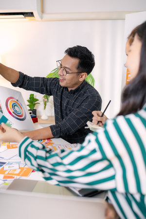 UX/UI designers presenting their final design project to the team, showcasing app interface screens and explaining user experience strategies in a professional creative office environment.の写真素材