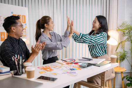 UX/UI designers collaborating during a creative workshop to test interface ideas and exchange feedback for app development, emphasizing teamwork and innovative design thinking.の写真素材