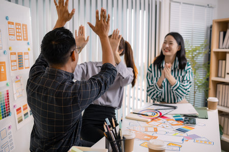 UX/UI designers collaborating during a creative workshop to test interface ideas and exchange feedback for app development, emphasizing teamwork and innovative design thinking.の写真素材