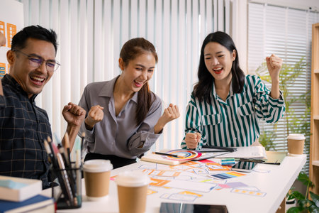 UX/UI designers collaborating during a creative workshop to test interface ideas and exchange feedback for app development, emphasizing teamwork and innovative design thinking.の写真素材