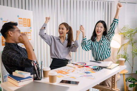 Designers having a UX/UI planning meeting to refine mobile app layouts and user flow. They collaborate closely to create functional and visually appealing interface solutions.の写真素材