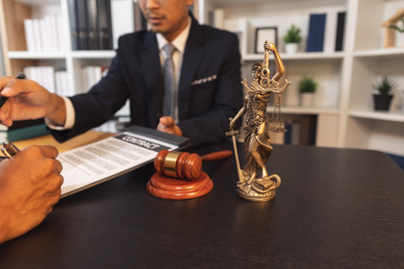 A professional lawyer discussing legal matters with a client in an office, providing legal advice and document review services, symbolizing justice, trust, and professional consultation.の写真素材