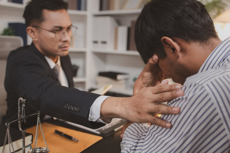 A professional lawyer discussing legal matters with a client in an office, providing legal advice and document review services, symbolizing justice, trust, and professional consultation.の写真素材