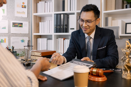 A professional lawyer discussing legal matters with a client in an office, providing legal advice and document review services, symbolizing justice, trust, and professional consultation.の写真素材