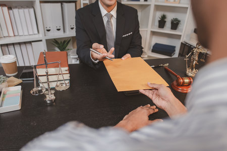 A professional lawyer discussing legal matters with a client in an office, providing legal advice and document review services, symbolizing justice, trust, and professional consultation.の写真素材