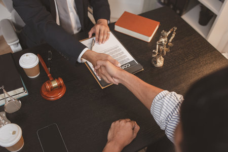 A professional lawyer discussing legal matters with a client in an office, providing legal advice and document review services, symbolizing justice, trust, and professional consultation.の写真素材