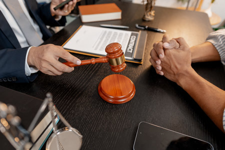 A professional lawyer discussing legal matters with a client in an office, providing legal advice and document review services, symbolizing justice, trust, and professional consultation.の写真素材
