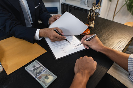 A professional lawyer discussing legal matters with a client in an office, providing legal advice and document review services, symbolizing justice, trust, and professional consultation.の写真素材