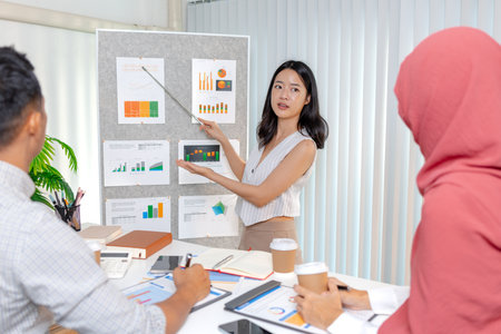 A team of diverse professionals engaged in a business presentation, discussing data and strategies together. The meeting shows teamwork, collaboration, and focus on business growth and success.の写真素材
