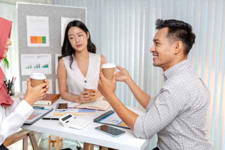 A group of diverse business professionals collaborating in a modern office, discussing charts and data analysis during a meeting. The atmosphere reflects teamwork, planning, and positive communication.の写真素材
