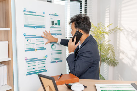 A business analyst examining charts and statistics on a whiteboard, using data-driven insights to guide financial strategy, business performance, and future organizational planning.の写真素材