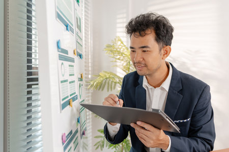 A professional businessman presenting financial analysis on charts, discussing marketing strategies and company goals to drive profitability, growth, and sustainable business development.の写真素材