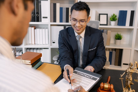 A professional lawyer discussing legal matters with a client in an office, providing legal advice and document review services, symbolizing justice, trust, and professional consultation.の写真素材