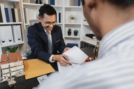 A professional lawyer discussing legal matters with a client in an office, providing legal advice and document review services, symbolizing justice, trust, and professional consultation.の写真素材