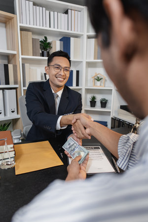 An act of bribery showing hands exchanging cash in a law office environment, symbolizing corruption, fraud, and moral issues in legal or business dealings.の写真素材