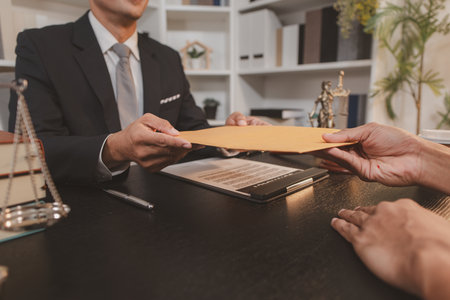 A professional lawyer discussing legal matters with a client in an office, providing legal advice and document review services, symbolizing justice, trust, and professional consultation.の写真素材