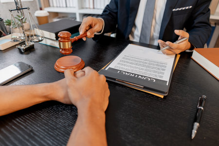 A professional lawyer discussing legal matters with a client in an office, providing legal advice and document review services, symbolizing justice, trust, and professional consultation.の写真素材