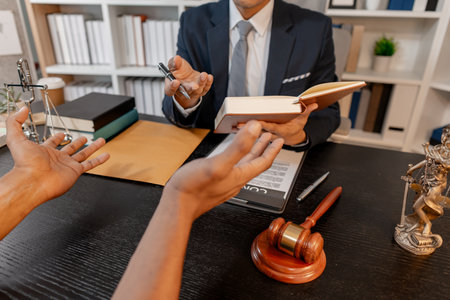 A professional lawyer discussing legal matters with a client in an office, providing legal advice and document review services, symbolizing justice, trust, and professional consultation.の写真素材