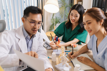 Team of doctors and nurses collaborating in a clinical environment, reviewing treatment options and sharing medical opinions to provide effective patient-centered healthcare solutions.の写真素材