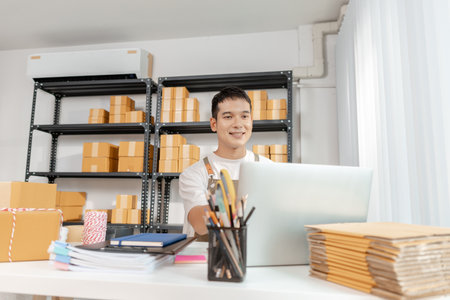 Young entrepreneur managing online business, preparing packages and working with e commerce operations, representing digital marketplace, startup growth and modern retail strategy.の写真素材