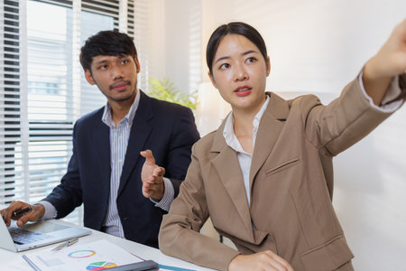 A group of business professionals engaged in a serious office discussion, analyzing financial reports and exchanging ideas to solve problems and make effective corporate decisions.の写真素材