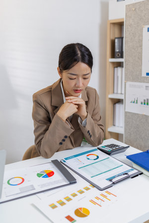 A group of business professionals engaged in a serious office discussion, analyzing financial reports and exchanging ideas to solve problems and make effective decisions.の写真素材