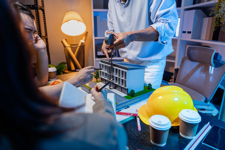 Engineers and architects analyze construction models and discuss project strategies, combining technical knowledge and creative ideas to achieve successful architectural design solutions.の写真素材