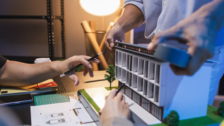 A group of engineers and architects collaborate on a construction project, discussing ideas and...