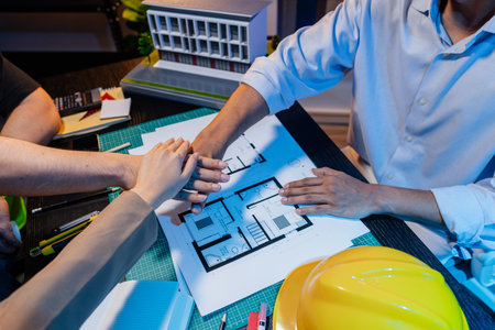 Engineers and architects analyze construction models and discuss project strategies, combining...