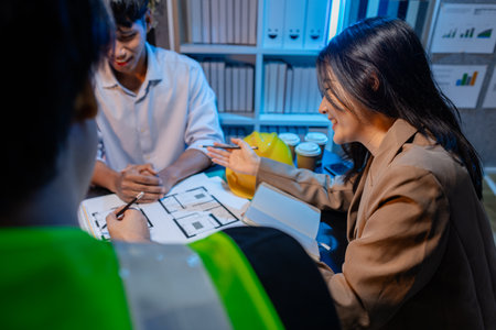 Engineers and architects analyze construction models and discuss project strategies, combining technical knowledge and creative ideas to achieve successful architectural design solutions.の写真素材