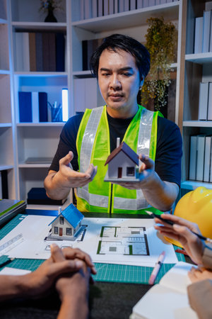 A group of engineers and architects collaborate on a construction project, discussing ideas and...