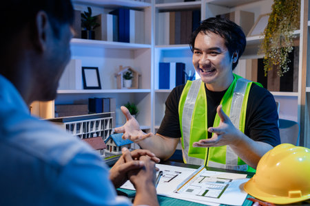 A group of engineers and architects collaborate on a construction project, discussing ideas and...