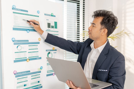 A business analyst examining charts and statistics on a whiteboard, using data-driven insights to guide financial strategy, business performance, and future organizational planning.の写真素材