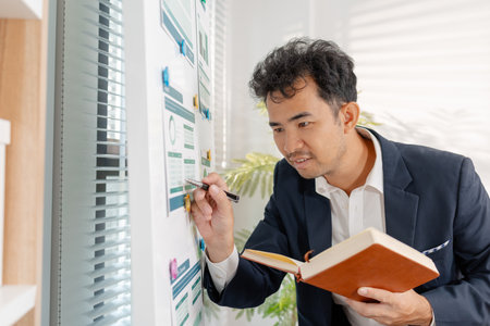 A professional businessman presenting financial analysis on charts, discussing marketing strategies and company goals to drive profitability, growth, and sustainable business development.の写真素材
