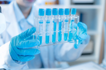 A chemistry researcher in a laboratory surrounded by scientific equipment and test tubes, representing innovation, scientific development, and modern medical research environment.の写真素材
