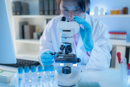A chemistry researcher in a laboratory surrounded by scientific equipment and test tubes, representing innovation, scientific development, and modern medical research environment.の写真素材