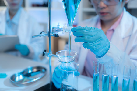 A chemistry researcher in a laboratory surrounded by scientific equipment and test tubes, representing innovation, scientific development, and modern medical research environment.の写真素材