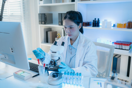 A chemistry researcher in a laboratory surrounded by scientific equipment and test tubes, representing innovation, scientific development, and modern medical research environment.の写真素材