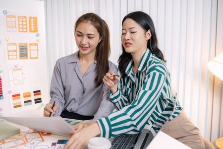 UX/UI designers presenting their final design project to the team, showcasing app interface screens and explaining user experience strategies in a professional creative office environment.の写真素材