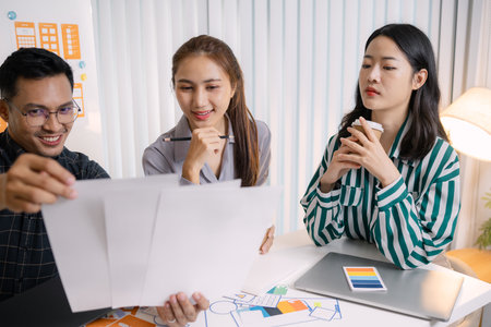 UX/UI designers presenting their final design project to the team, showcasing app interface screens and explaining user experience strategies in a professional creative office environment.の写真素材