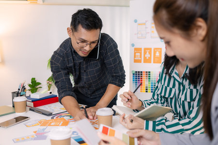 UX/UI designers presenting their final design project to the team, showcasing app interface screens and explaining user experience strategies in a professional creative office environment.の写真素材