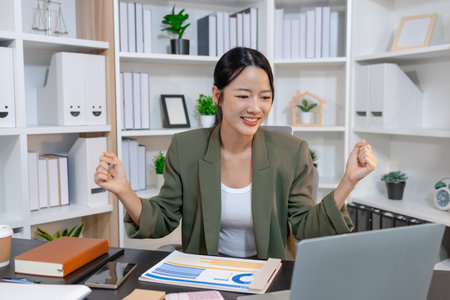 Professional businesswoman reviewing financial reports and taking notes at her workspace, focused on planning, decision making, and data analysis to support strategy and effective management.の写真素材