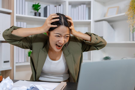Stressed businesswoman dealing with heavy work pressure, reacting emotionally while reviewing reports and facing tight deadlines, highlighting workplace stress and modern professional challenges.の写真素材