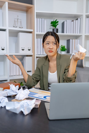 Stressed businesswoman dealing with heavy work pressure, reacting emotionally while reviewing reports and facing tight deadlines, highlighting workplace stress and modern professional challenges.の写真素材