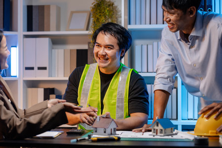 A team of architects and engineers coordinates on an architectural project, reviewing design concepts and technical plans to ensure efficiency and creativity in modern construction development.の写真素材