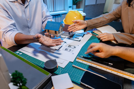 Engineers and architects analyze construction models and discuss project strategies, combining...